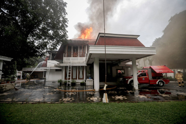 Petugas pemadam kebakaran berusaha memadamkan api di rumah mewah di Jalan Sutan Syahrir No. 43, kawasan Menteng, Jakarta Pusat, Selasa (9/7/2024).  Foto: Jamal Ramadhan/kumparan