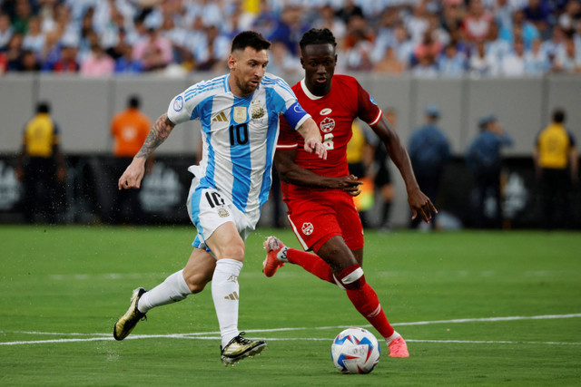 Pemain Timnas Argentina Lionel Messi berebut bola dengan pemain Timnas Kanada Ismael Kone pada pertandingan semifinal Copa America 2024 di Stadion MetLife, New Jersey, Amerika Serikat, Rabu (10/7/2024). Foto: EDUARDO MUNOZ / AFP