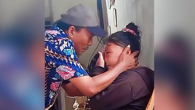 Ayah korban sambil menangis memeluk anaknya yang sudah babak belur dianiaya suami. (foto: capture video)