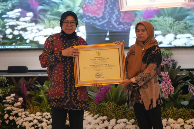 Neng Cicah Kurniawati, guru di SD Cikuya 1, Desa Bandasari, Kecamatan Cangkuang, Kabupaten Bandung menerima piagam penghargaan dari Mensos Tri Rismaharini di Kemensos, Jakarta. Foto: Dok. Istimewa