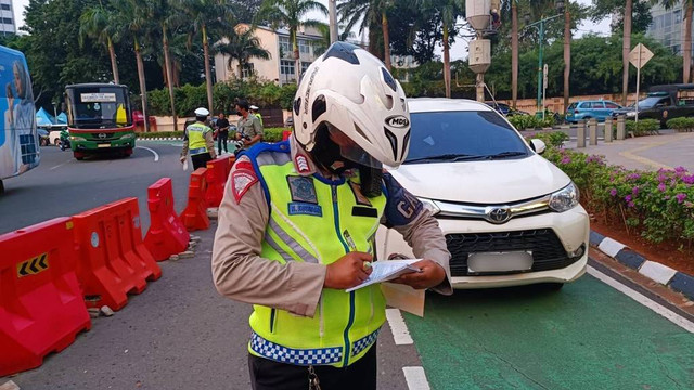 Polisi membali melakukan tilang manual di Bundaran HI, Jakarta, Senin (15/5/2023). Foto: Thomas Bosco/kumparan