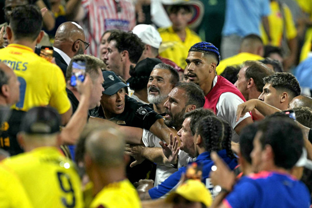 Suporter Kolombia (kiri) bentrok dengan bek Uruguay Ronald Araujo (kanan) di akhir pertandingan sepak bola semifinal Copa America 2024. Foto: Juan Mabromata/AFP