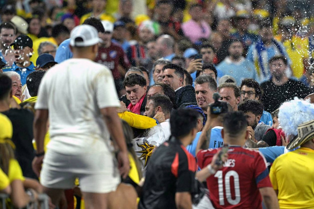 Suporter Kolombia (kiri) bentrok dengan bek Uruguay Ronald Araujo (kanan) di akhir pertandingan sepak bola semifinal Copa America 2024. Foto: Juan Mabromata/AFP