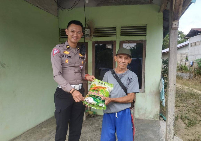 Plh Kasat Lantas Polres Sekadau menyerahkan bantuan beras kepada warga. Foto: Dok. Polres Sekadau