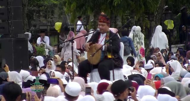 [Tangkapan Layar TV Tabalong] Pamadihin Anang Syahrani menampilkan seni tutur Madihin dihadapan Presiden Joko Widodo pada Muktamar Rabithah Melayu-Banjar. Kegiatan tersebut berlangsung pada 27 Maret 2023 lalu, di halaman Pendopo Pembataan Pemkab Tabalong, Kalimantan Selatan.