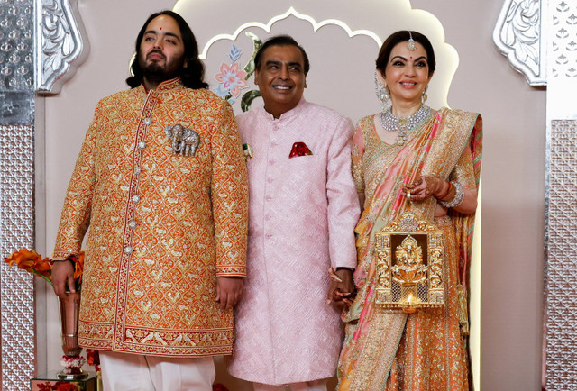 Pengantin pria Anant Ambani berfoto bersama Nita Ambani dan Mukesh Ambani di karpet merah pada hari pernikahannya dengan Radhika Merchant di Mumbai, India, 12 Juli 2024. Foto: REUTERS/Francis Mascarenhas