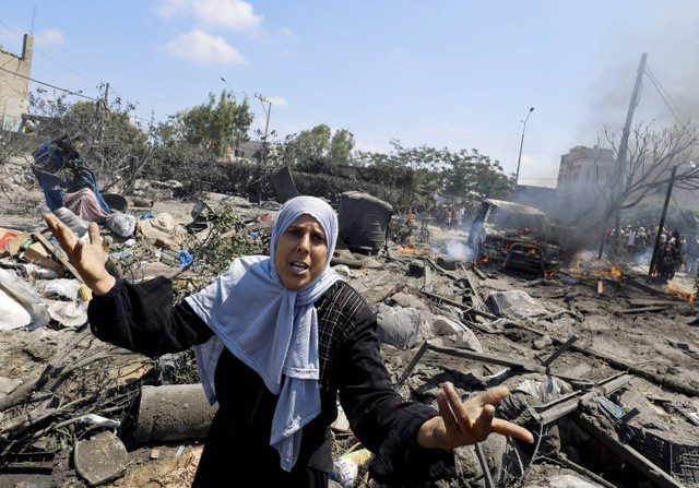 Seorang wanita Palestina bereaksi di dekat kerusakan akibat serangan Israel di sebuah tenda pengungsian di daerah Al-Mawasi, Khan Younis di Jalur Gaza selatan, Sabtu (13/7/2024). Foto: Mohammed Salem/Reuters