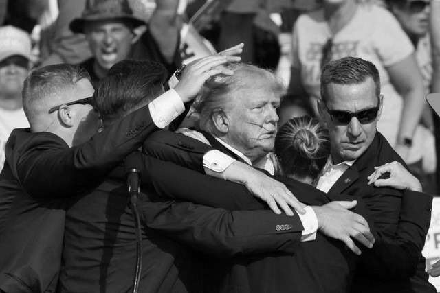 Kandidat calon presiden dari Partai Republik dan mantan Presiden AS Donald Trump dibantu oleh Secret Service setelah terdengar suara tembakan dalam sebuah acara kampanye di Butler Farm Show di Butler, Pennsylvania, AS, (13/7/2024) waktu setempat. Foto: Brendan McDermid/REUTERS 