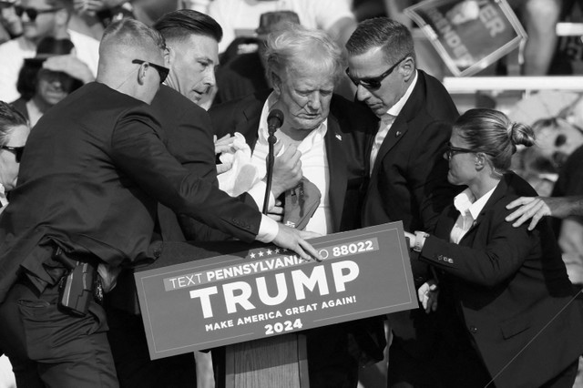 Kandidat presiden dari Partai Republik dan mantan Presiden AS Donald Trump dibantu oleh petugas keamanan setelah terdengar suara tembakan dalam sebuah acara kampanye di Butler Farm Show di Butler, Pennsylvania, AS, (13/7/2024) waktu setempat. Foto: Brendan McDermid/REUTERS 