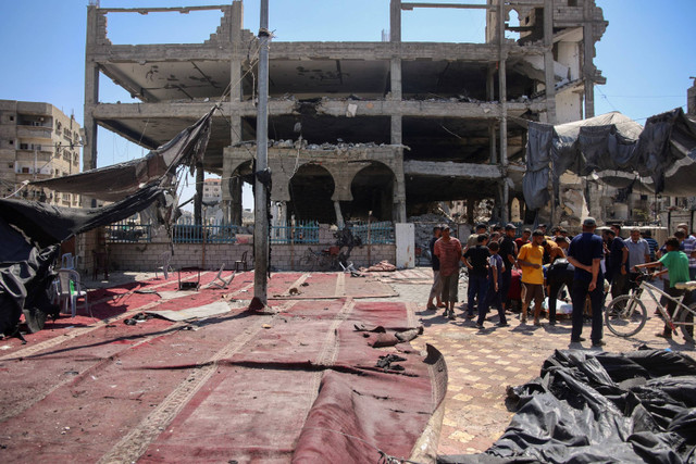 Warga Palestina meninjau kerusakan lokasi serangan Israel yang menghantam masjid darurat di kamp pengungsi Al-Shati, Kota Gaza, Sabtu (13/7/2024). Foto: Omar AL-QATTAA / AFP