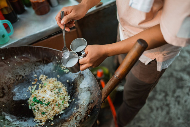 Ilustrasi memberikan bumbu ke masakan nasi goreng. Foto: Shutterstock