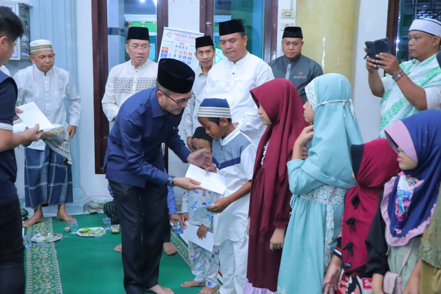 Sekda Kota Palembang, Ratu Dewa, saat menyalurkan bantuan untuk anak yatim. (ist)