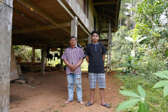 Moses Patibang (kanan) bersama bapaknya Natan Kapitong (kiri) yang seorang petani Singkong berpose di depan rumahnya, Mengkendek, Kabupaten Tana Toraja.  Foto: Dok. Humas UGM