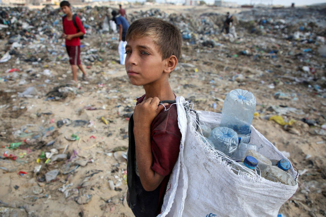 Seorang anak mencari barang-barang yang dapat digunakan di tempat pembuangan sampah di Khan Younis, Jalur Gaza, Senin (15/7/2024). Foto: Hatem Khaled/REUTERS