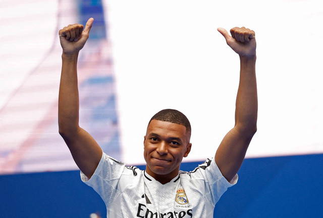 Pemain baru Real Madrid, Kylian Mbappe, menyapa para penonton saat presentasi di Santiago Bernabeu, Madrid, Spanyol, Selasa (16/7/2024). Foto: Juan Medina/REUTERS