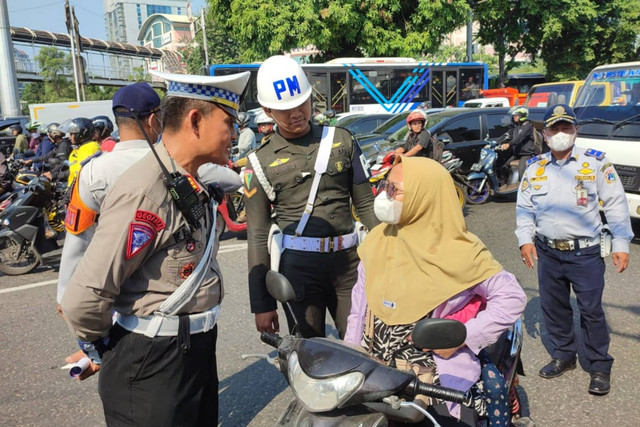 Anggota kepolisian melakukan himbauan kepada pengendara yang melanggar peraturan saat Operasi Patuh Jaya 2024 di Grogol, Jakarta Barat, Rabu (17/7/2024). Foto: Rachmadi Rasyad/kumparan