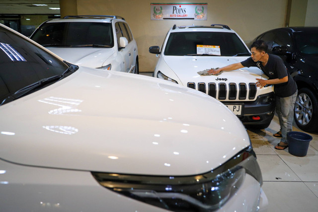 Pekerja  membersihkan mobil bekas yang dijual di Blok M, Jakarta, Rabu (17/7/2024). Foto: Iqbal Firdaus/kumparan