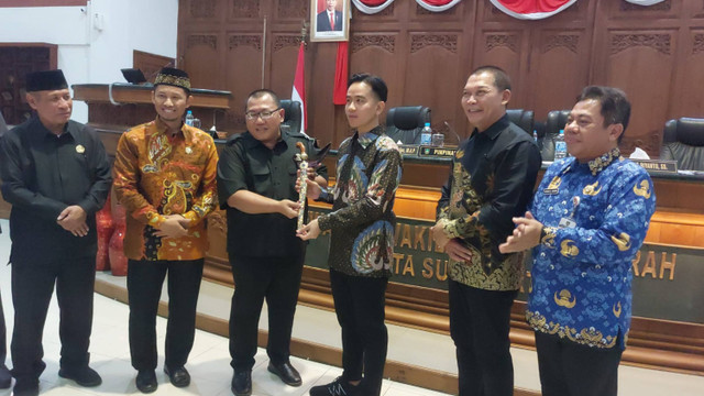 Ketua DPRD Solo Budi Prasetyo secara simbolis memberikan kenang-kenangan keris pada Wali Kota Solo Gibran Rakabuming Raka setelah pengajuan mundur diterima DPRD Solo, Rabu (17/7/2024). Foto: kumparan