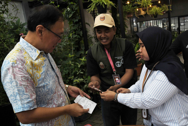 Petugas Pemutakhiran Data Pemilih (Pantarlih) KPU (kanan) menulis surat pemutakhiran data saat melakukan pencocokan dan penelitian (coklit) data pemilih di Margahayu, Bekasi, Jawa Barat, Kamis (11/7/2024). Foto: Fakhri Hermansyah/ANTARA FOTO