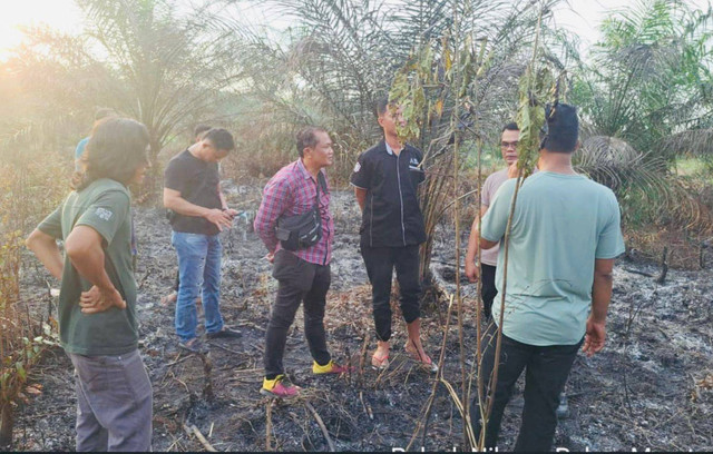 Petugas kepolisian saat melakukan olah TKP di lokasi kebun yang terbakar. (ist)