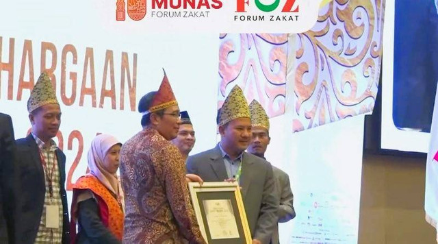 Wakil Direktur 1 Yatim Mandiri, Irfan Fauzi menerima penghargaan dari Prof. Dr. Waryono dari Dirjen Pemberdayaan Zakat dan Wakaf.