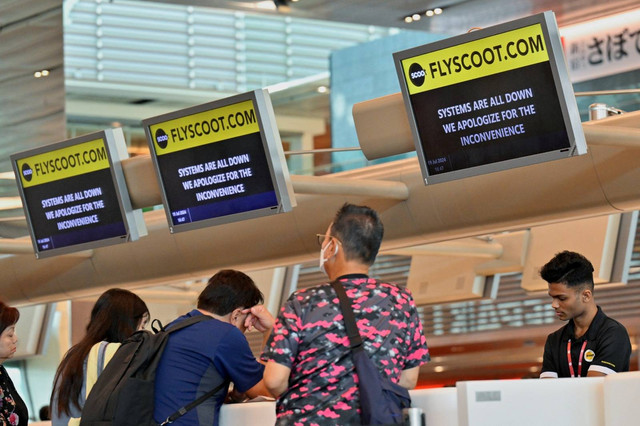 Penumpang Scoot menunggu untuk check-in secara manual di Terminal 1 Bandara Changi, Singapura, Jumat (19/7/2024). Foto: Caroline Chia/REUTERS