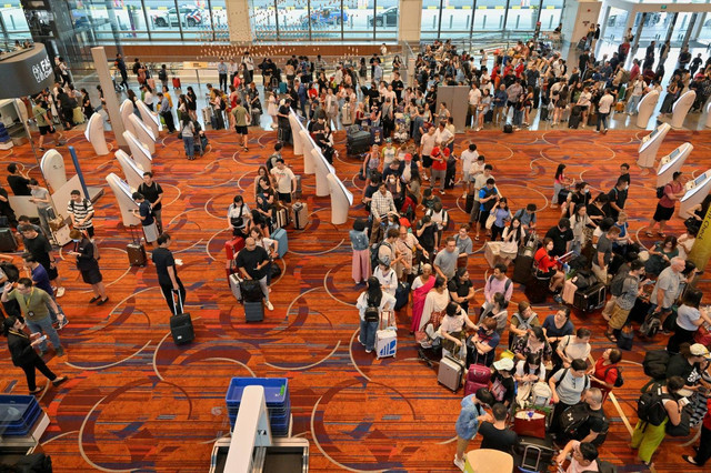 Penumpang Scoot menunggu untuk check-in secara manual di Terminal 1 Bandara Changi, Singapura, Jumat (19/7/2024). Foto: Caroline Chia/REUTERS