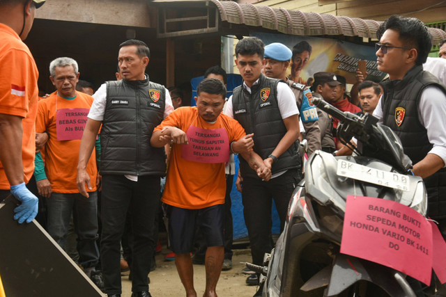 Bebas Ginting (kiri) dan Yunus Saputra Tarigan (tengah), tersangka pembakaran rumah wartawan di Karo, Sumatera Utara, Jumat (19/7/2024). Foto: ANTARA FOTO/Fransisco Carolio