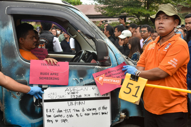 Tersangka kasus pembakaran rumah wartawan Rudi Apri Sembiring (kiri) memperagakan adegan saat rekonstruksi di Kabanjahe, Karo, Sumatera Utara, Jumat (19/7/2024). Foto: ANTARA FOTO/Fransisco Carolio