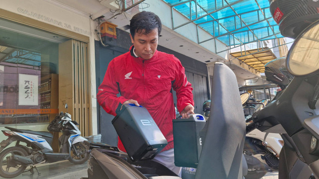 Petugas Honda Care saat melayani pengendara motor listrik untuk penggantian baterai di Jalan Gajah Mada, Kota Medan, pada Senin (22/7/2024).  Foto: Dok. AHM 