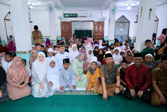 Ketua DWP Palembang Dewi Sastrani Dewa didampingi Camat Gandus Jufriansyah saat memberikan santunan bagi anak yatim piatu dan kaum dhuafa, Foto : Ist