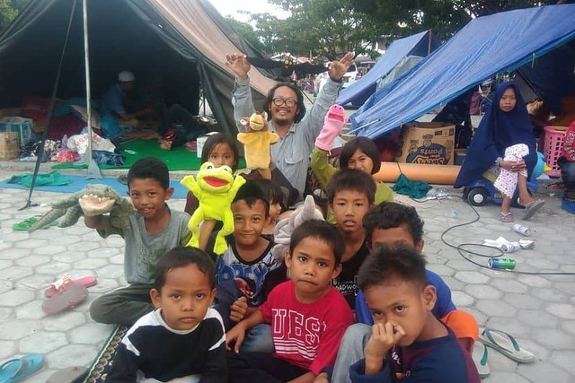 Bahan Patria Gupta, pemilik Perpustakaan Boneka, saat bersama anak-anak pengungsian bencana gempa di Palu. Foto: Dok. pribadi