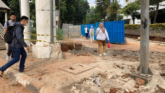 Pejalan kaki melintasi proyek galian dan pembangunan trotoar di Jalan HR Rasuna Said, Kuningan, Jakarta Selatan, Rabu (24/7). Foto: Alya Nurfakhira Zahra