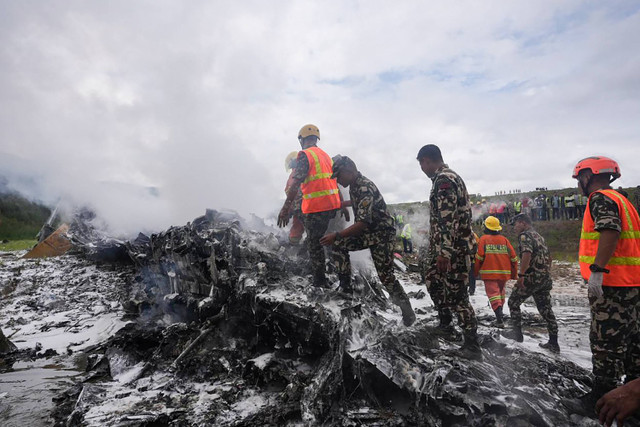 Petugas memeriksa pesawat Saurya Airlines yang terjatuh di Kathmandu, Nepal, Rabu (24/7/2024).
 Foto: Prakash Mathema/AFP