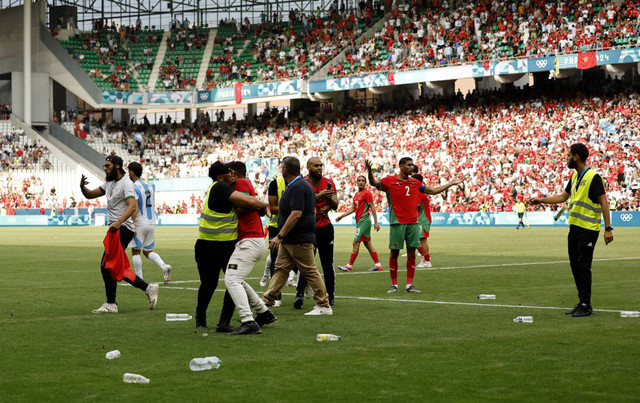 Suporter masuk lapangan saat Argentina vs Maroko di Olimpiade. Foto: Thaier al-Sudani/Reuters