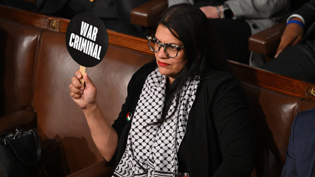 Perwakilan AS Rashida Tlaib, Demokrat dari Michigan, melakukan protes dengan mengangkat poster "Penjahat Perang" selama pidato Perdana Menteri Israel Benjamin Netanyahu pada pertemuan gabungan Kongres di US Capitol pada 24 Juli 2024, di Washington, DC. Foto:  SAUL LOEB/AFP