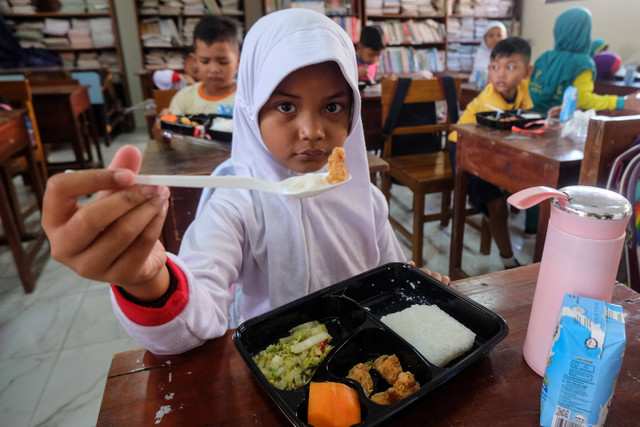 Siswa menunjukkan makanan bergizi gratis saat simulasi program makan siang gratis di SD Negeri Tugu, Solo, Jawa Tengah, Kamis (25/7/2024). Foto: ANTARAFOTO/Maulana Surya