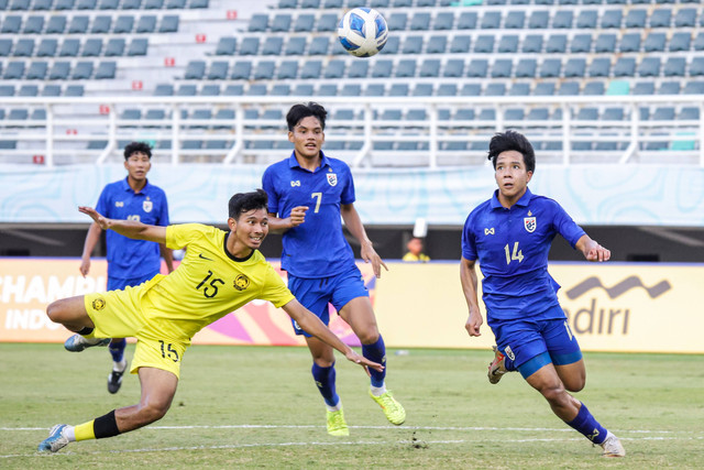 Pesepak bola Timnas Malaysia Muhammad Aiman Hakimi (kiri) berebut bola dengan pesepak bola Timnas Thailand Jirapong Pungviravong (kanan) pada penyisihan grup C Piala AFF U-19 di Stadion Gelora Bung Tomo, Surabaya, Kamis (25/7/2024).   Foto: Rizal Hanafi/ANTARA FOTO