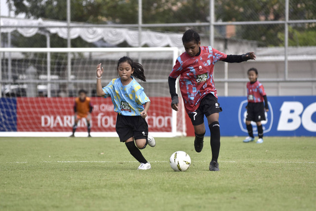 Pesepak bola SD Kristen Manahan Ika Wonda (kanan) menguasai bola yang berusaha direbut pemain SDN Cengklik Kanaya Akiva Wijaya Napa pada KU 10 Milklife Soccer Challenge-Solo Series 1 2024, Kamis (25/7). SD Kristen Mahanan menang 2-0. Foto: Aset MilkLife Soccer Challenge