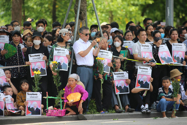 Warga mengikuti prosesi pemakaman Sekertaris Jenderal Partai Komunis Vietnam Nguyen Phu Trong di Hanoi, Vietnam, Jumat (26/7/2024).   Foto: LUONG THAI LINH / POOL / AFP