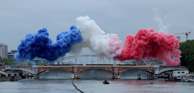 Suasana pemandangan awan moke dengan tiga warna bendera Prancis terlihat saat pembukaan Olimpiade Paris 2024 di Paris, Prancis, Sabtu (27/7/2024). Foto: ANN WANG/Reuters