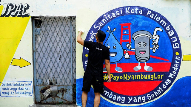 Warga yang sedang melukis mural di dinding salah satu blok rusun Palembang yang nantinya akan digagas sebagai kampung sanitasi Agustus mendatang, Sabtu (27/7) Foto: ary priyanto