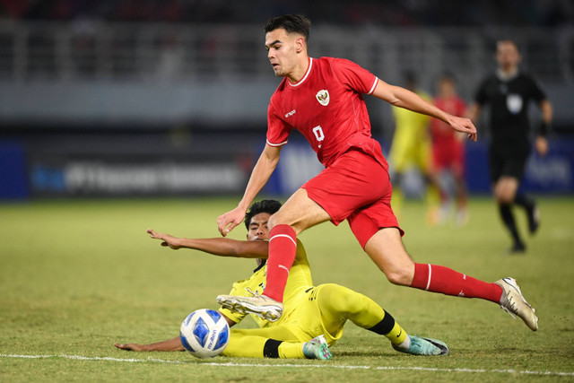 Pesepak bola Timnas Indonesia Jens Raven (atas) berupaya melewati pesepak bola Timnas MalaysiaAriff Safwan Bin Mohd Safri (bawah) dalam pertandingan semifinal Piala AFF U-19 di Stadion Gelora Bung Tomo, Surabaya, Jawa Timur, Sabtu (27/7/2024). Foto: Sigid Kurniawan/ANTARA FOTO 