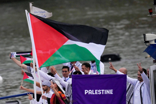 Kontingen Palestina mengikuti defile dengan menaiki kapal menyusuri sungai Seine saat pembukaan Olimpiade Paris 2024 di Paris, Prancis, Kamis (26/7/2024). Foto: Kirsty Wigglesworth/AP Photo