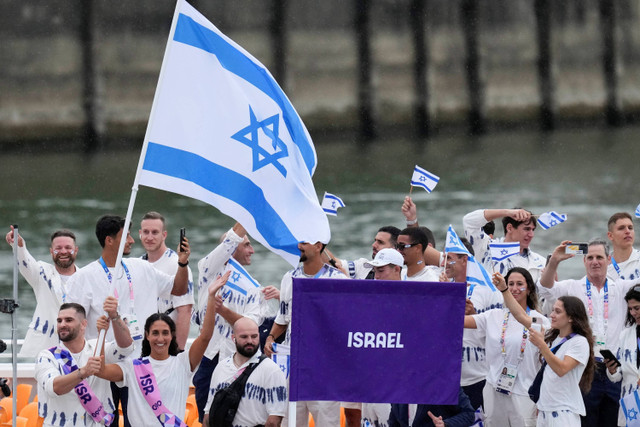 Pendukung Israel mengibarkan bendera sebelum dimulainya pertandingan sepak bola grup D putra antara Israel dan Paraguay pada Olimpiade Paris 2024 di Parc des Princes di Paris, Prancis, Sabtu (27/7/2024). Foto: Lindsey Wasson/AP PHOTO