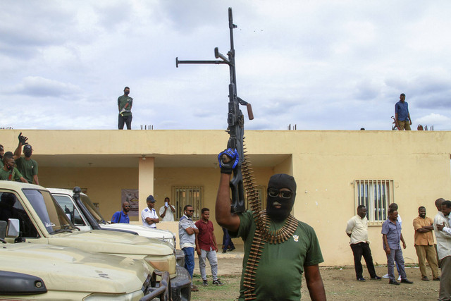 Anggota 'sel keamanan gabungan' yang terdiri dari berbagai layanan militer dan keamanan yang berafiliasi dengan tentara Sudan, mengacungkan senapan saat parade di kota Gedaref, Sudan, Minggu (28/7/2024). Foto: AFP