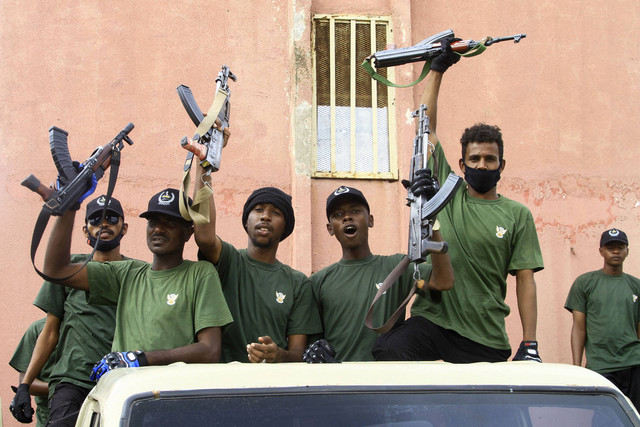 Anggota 'sel keamanan gabungan' yang terdiri dari berbagai layanan militer dan keamanan yang berafiliasi dengan tentara Sudan, mengacungkan senapan saat parade di kota Gedaref, Sudan, Minggu (28/7/2024). Foto: AFP