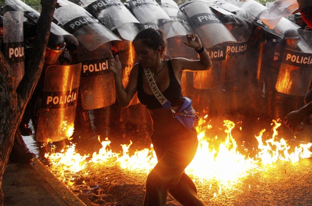 Seorang demonstran bereaksi ketika bom molotov menghantam tanah di depan pasukan keamanan selama protes terhadap hasil pemilu presiden di Venezuela, Minggu (29/7/2024). Foto: Samir Aponte/REUTERS