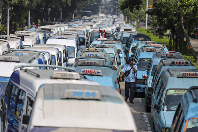 Ratusan mobil JakLingko dan mikrolet terparkir saat melakukan aksi unjuk rasa di depan Balai Kota, Jakarta pada Selasa (30/7/2024). Foto: Iqbal Firdaus/kumparan