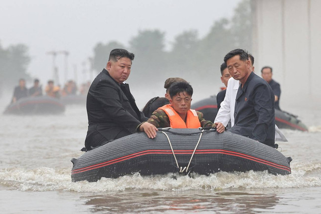 Pemimpin Korea Utara Kim Jong-un dan Perdana Menteri Kim Tok Hun menaiki perahu karet meninjau daerah yang terkena dampak banjir dekat perbatasan dengan China di Provinsi Pyongan Utara, Korea Utara. Foto: KCNA/via REUTERS